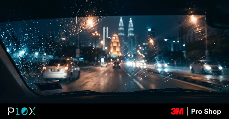 Window tint night driving in Malaysia showing glare reduction through a car windshield on a rainy KL road at night