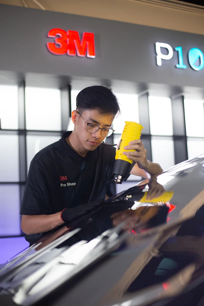Technician using a heat gun on windscreen film at 3M Pro Shop.