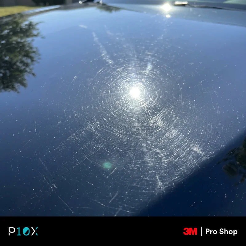 Checking car paint at a low angle in direct sunlight to reveal swirl marks