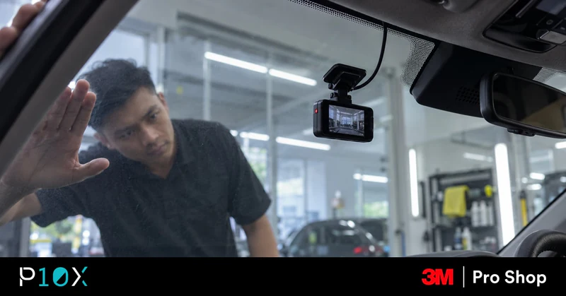 Dashcam behind a freshly tinted windscreen being checked in a tint bay
